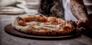 Freshly baked Margherita pizza steaming on a board at Vesu Pizza Bar in Tsim Sha Tsui, Hong Kong.