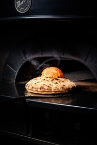 Puffed Neapolitan pizza dough emerging from the wood-fired oven at Vesu Pizza Bar, Tsim Sha Tsui